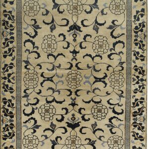 Beige rug with black and gray scrolling floral pattern and a geometric Greek key border.