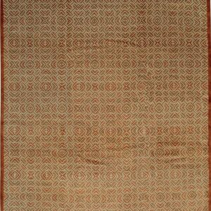 Low pile rug with an all-over repeating geometric pattern in rust orange and cream colors.