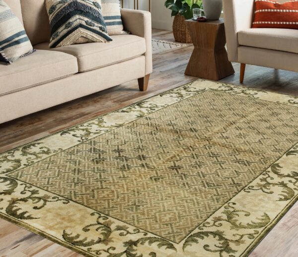 Beige rug with green lattice and scrolling borders anchors a neutral living room with wood flooring.