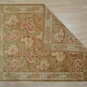 Traditional brown rug with cream and pink paisley and floral patterns on light wood floor.