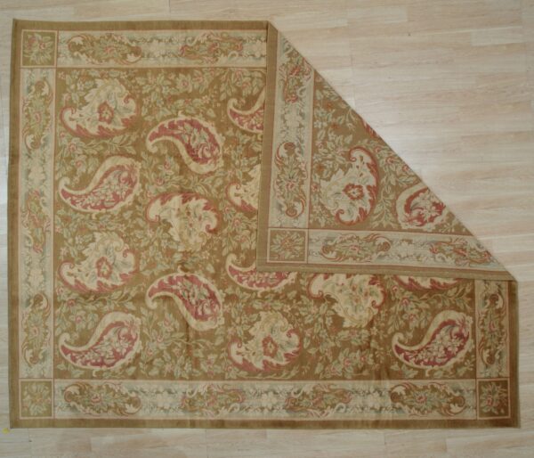 Traditional brown rug with cream and pink paisley and floral patterns on light wood floor.