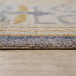 Textured tan and blue rug edge with blurred geometric patterns rests on a light wood plank floor.