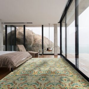 Blue, yellow, and rust patterned rug laid on dark wood flooring in a modern bedroom overlooking large rocks.