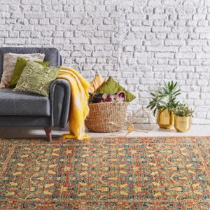 Traditional rust and gold patterned rug anchors a living area with a gray couch and white brick wall.