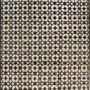 Dark brown and light beige rug with a repeating geometric quatrefoil pattern.