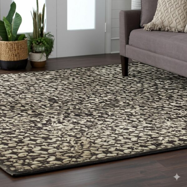 This black and beige mottled rug is set on dark flooring next to a gray couch and potted plants.