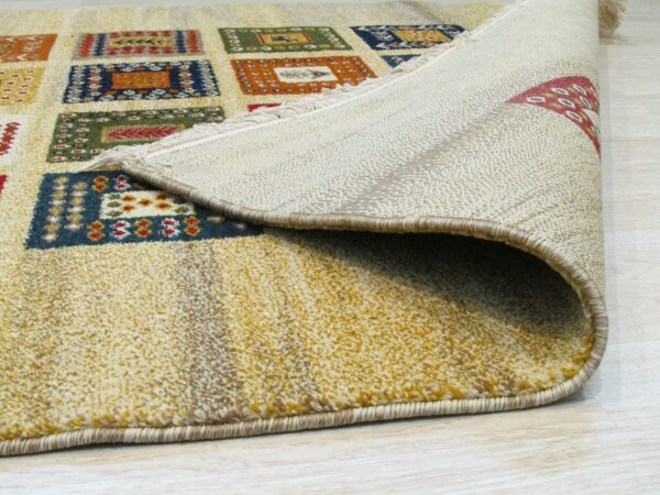 A medium-pile rug in yellow, blue, orange, and green geometric squares is rolled up on light flooring.