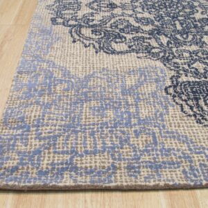 Highly textured rug with navy and light blue distressed patterns resting on light wood floor planks.