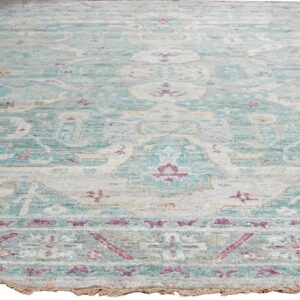 Faded traditional rug with low pile features teal, light gray, and magenta floral patterns.