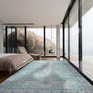 A distressed teal, cream, and magenta patterned rug rests on the wood floor of a modern bedroom.