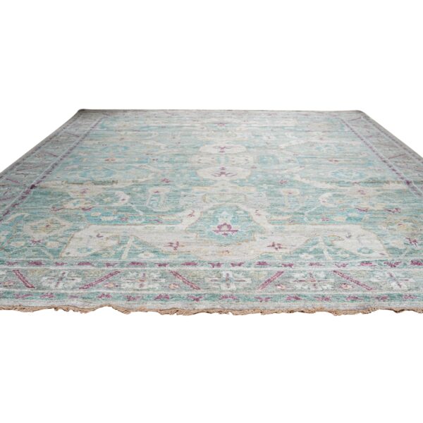 Teal and cream distressed rug with subtle magenta accents, shown on a white background.