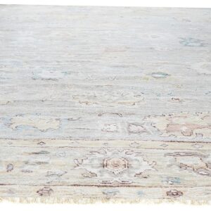 Pale gray low-pile rug featuring a distressed traditional floral pattern in muted blue, peach, and tan.