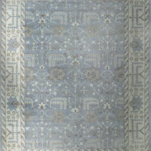 Low-pile rug in light blue and cream with traditional geometric floral motifs and short fringe.