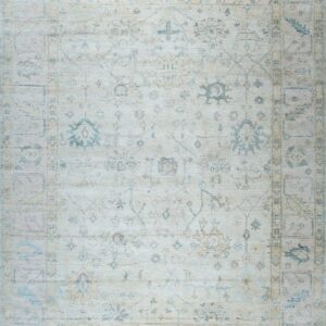 A light traditional rug with faded blue and tan geometric patterns on an ivory field.