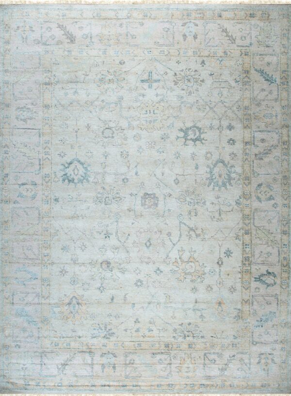 A light traditional rug with faded blue and tan geometric patterns on an ivory field.