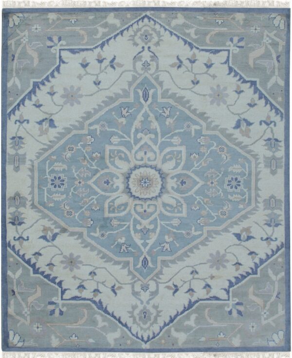 Muted light blue and cream traditional rug with a central geometric medallion and floral border details.