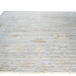 Pale gray rug featuring horizontal texture, subtle traditional motifs in beige and brown, and white fringe.