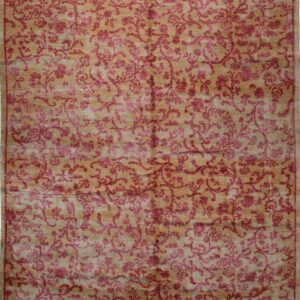 Full view of a golden tan rug featuring a dense all-over magenta floral vine pattern and subtle border.