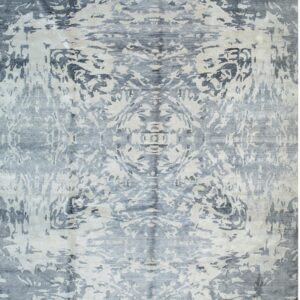 Symmetrical abstract rug featuring distressed dark gray and light beige patterns with a visible luster.