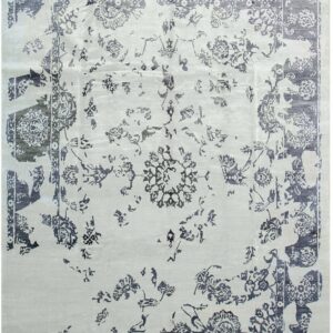 A rectangular, low-pile rug features an intentional distressed design with indigo botanical patterns over a pale gray field.