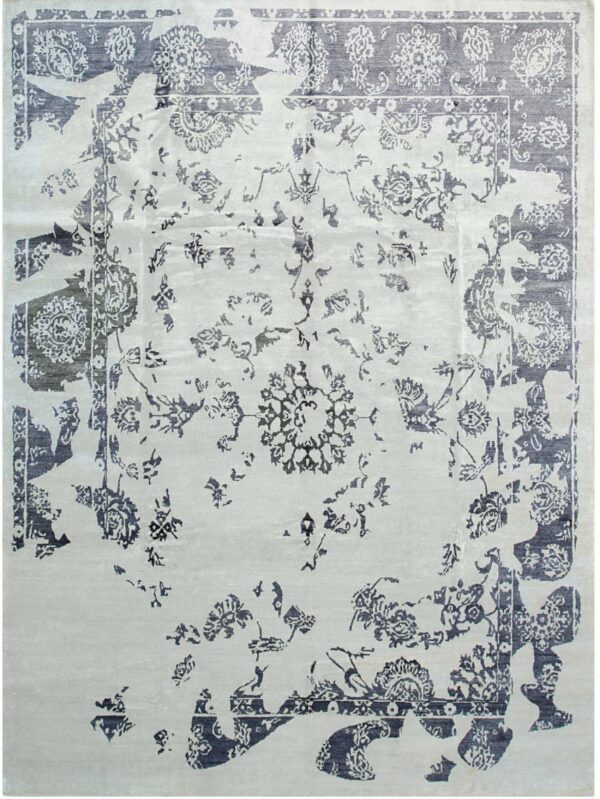 A rectangular, low-pile rug features an intentional distressed design with indigo botanical patterns over a pale gray field.