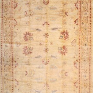 Pale yellow rug with scattered traditional motifs in red and blue, framed by an intricate border.