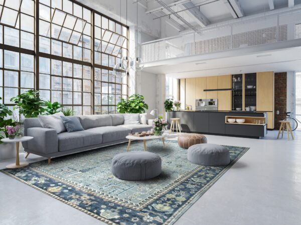 Distressed teal and navy traditional rug anchors a modern loft space with a gray sectional sofa.