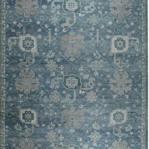 Slate blue rug with an overall traditional pattern featuring taupe, cream, and dark teal motifs.