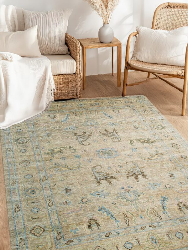 Beige and pale blue traditional rug defines a bright seating area with wicker furniture on wood flooring.