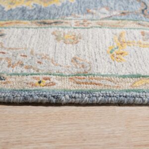 Detail of a plush rug featuring blue, cream, and yellow ornate patterns on light wood flooring.