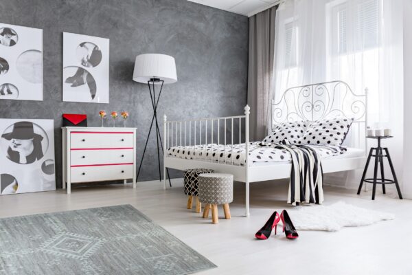 A gray, low-pile rug with a light geometric pattern sits on a light floor in a modern bedroom.