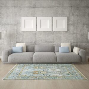 Traditional light blue and gold rug on wood flooring in a minimalist room with a gray sofa.