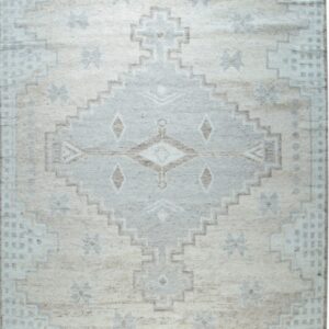 Cream and gray geometric rug with a large stepped medallion and tribal motifs on a textured pile.