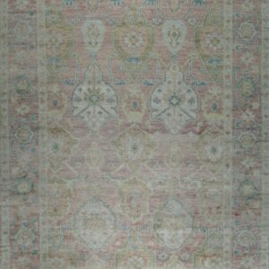 Dusty rose traditional rug with low pile and faded designs in light teal and beige.
