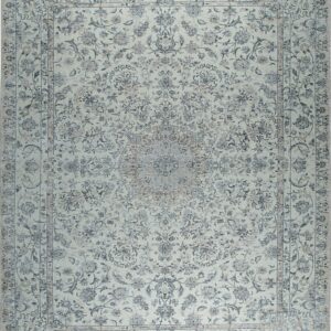 Traditional rug with a charcoal floral pattern against a faded cream and pale gray background.