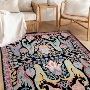 Black rug patterned with colorful stylized floral and abstract shapes placed near natural wood furniture.