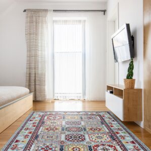 Geometric pale blue and multi-color area rug on a wood floor beneath a large window and TV.