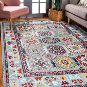 Light blue geometric rug with red, yellow, and navy details rests beneath a pink chair and gray sofa.