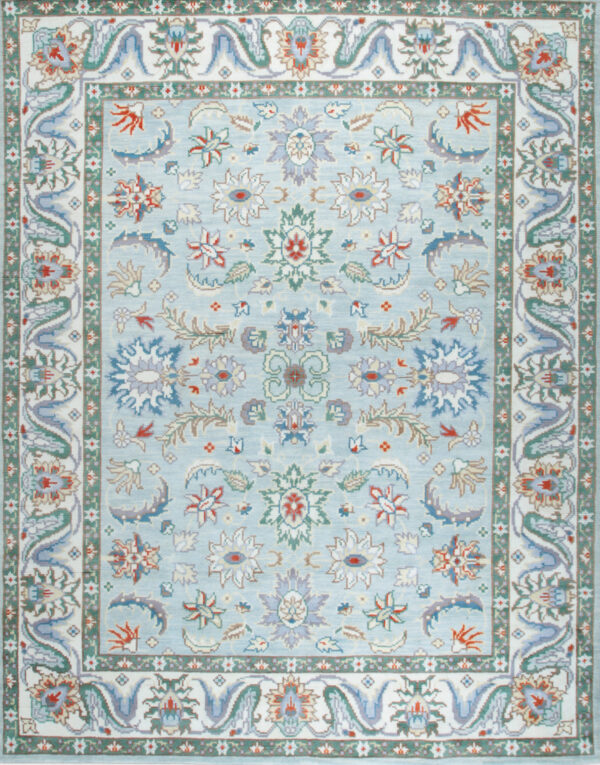 Ornate pale blue rug with a dense floral pattern and complex white, green, and lavender borders.