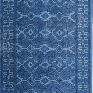 Monochromatic blue rug displaying a distressed finish and repetitive traditional geometric medallion patterns.