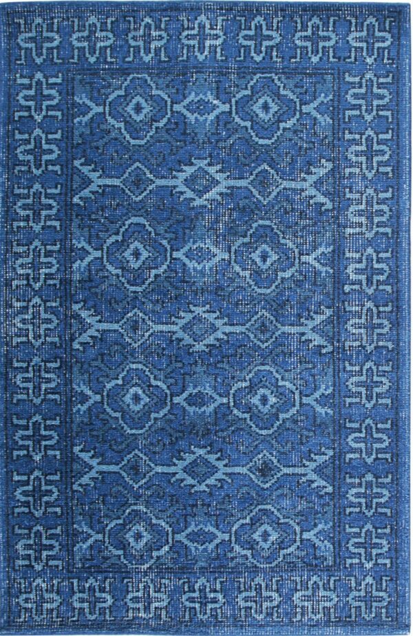 Monochromatic blue rug displaying a distressed finish and repetitive traditional geometric medallion patterns.