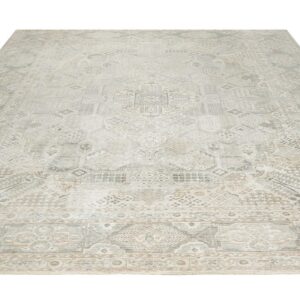 A large rectangular rug featuring complex faded geometric patterns in light gray, beige, and cream tones.