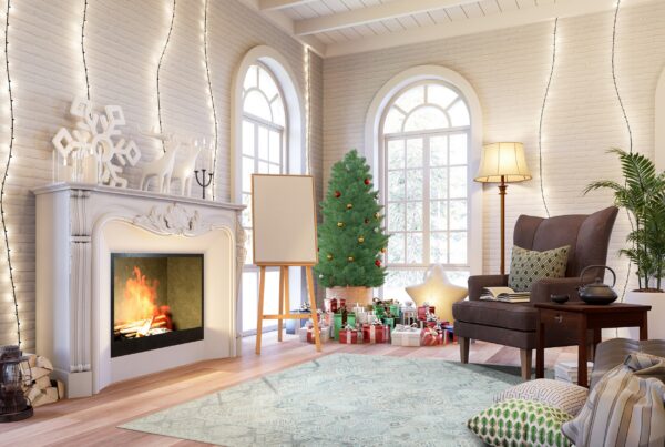 A pale blue patterned rug lies on hardwood floors in a festive room with a fireplace and christmas tree.