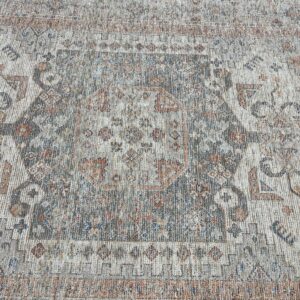 Distressed traditional rug in gray and cream colors with rust and blue accents and a faded medallion design.