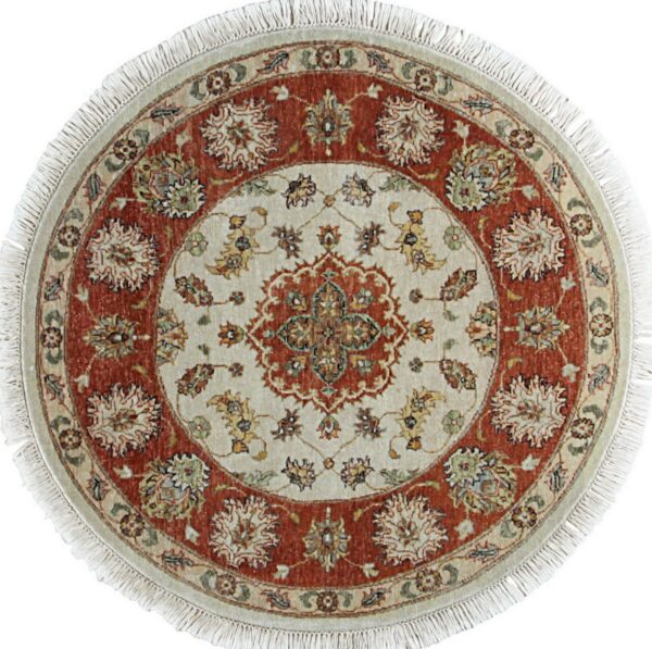 Circular rug displaying a traditional cream and terracotta floral medallion design with fringe.