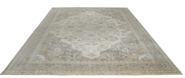 Muted traditional rug in soft gray, off-white, and beige colors featuring an ornate distressed central medallion.