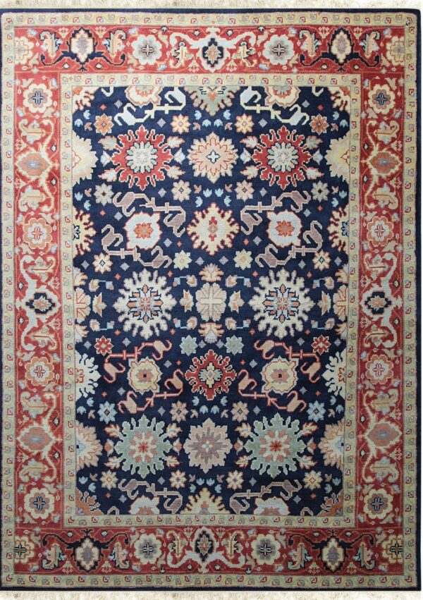 A high-pile navy rug with an ornate floral design and thick borders in red and pale yellow.