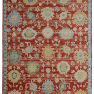 A traditional rug with a deep red field and stylized medallions in light blue, yellow, and cream.