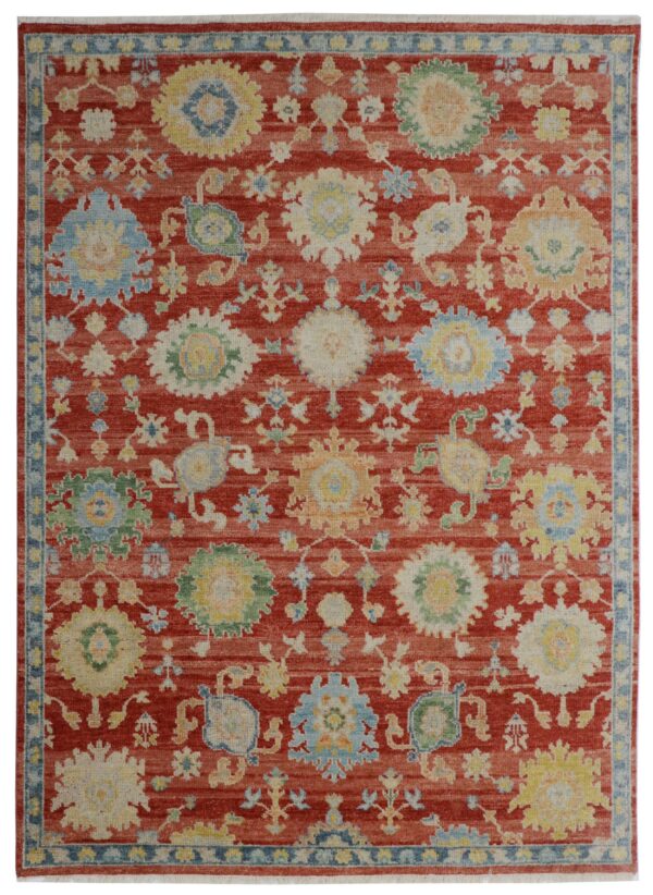 A traditional rug with a deep red field and stylized medallions in light blue, yellow, and cream.