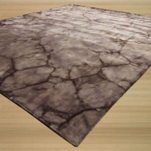 A flat, low-pile brown and gray rug with a cracked stone pattern rests on light wood flooring.